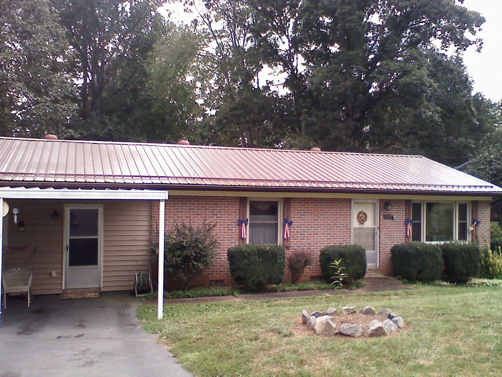 Bronze metal roof and carport on a brick ranch home — Roof Repair work by our crew in Drums